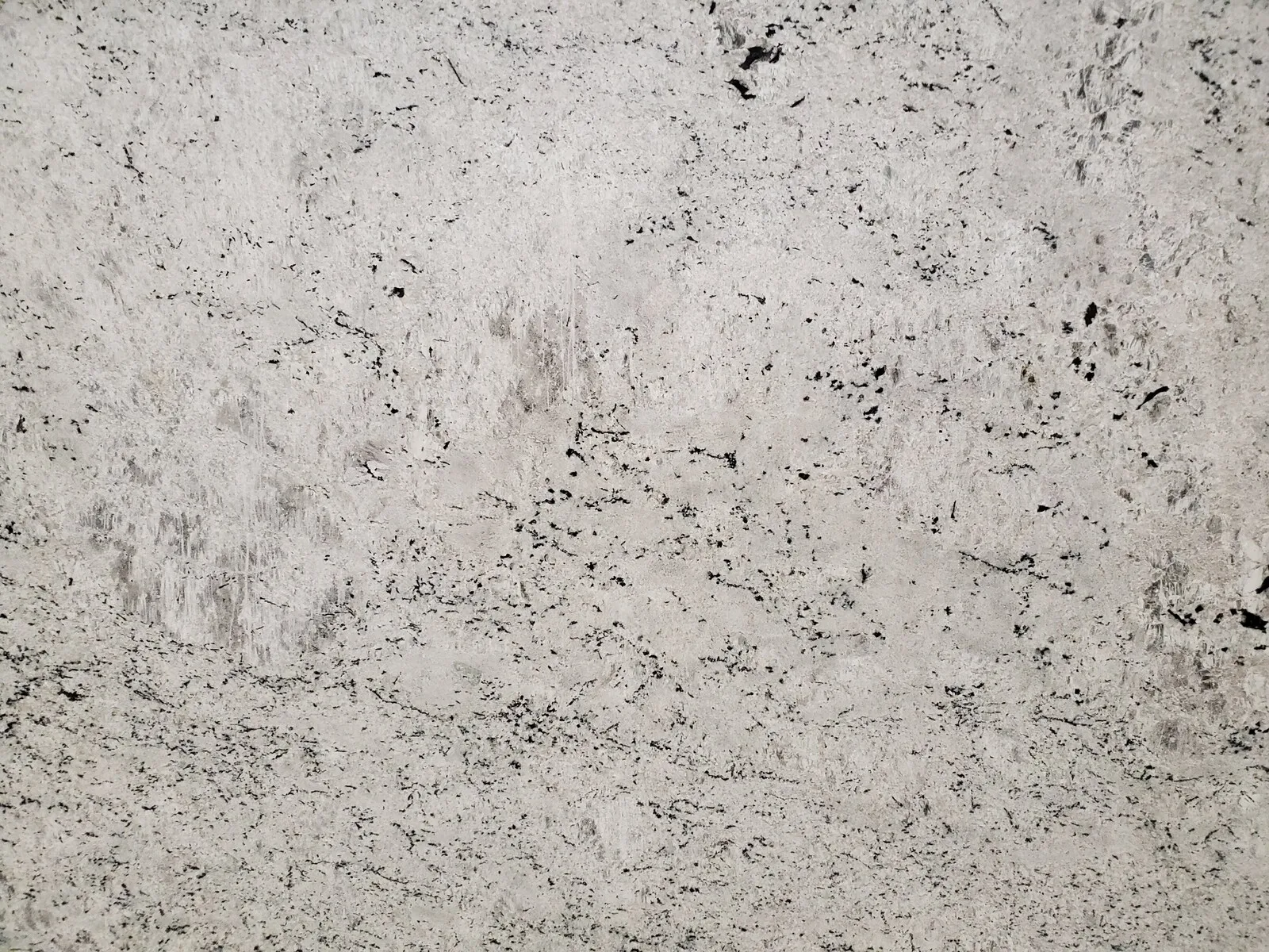 Closeup image of Colonial White Grey Granite countertop slab